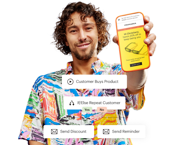 A man holding phone with mailchimp app on screen